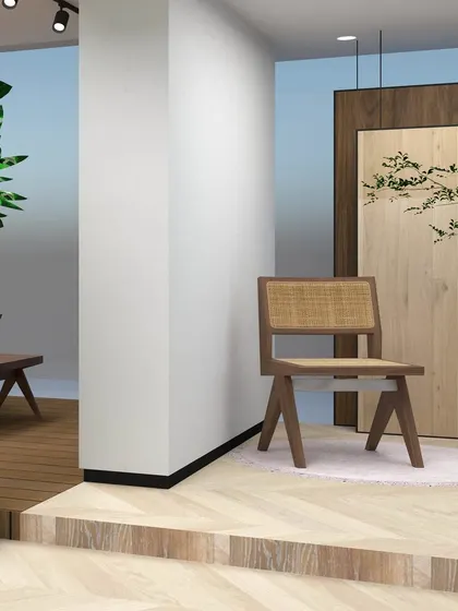 This render details a display corner with a classic caned chair and a raised wooden platform, illustrating how we create distinct zones within a larger space.