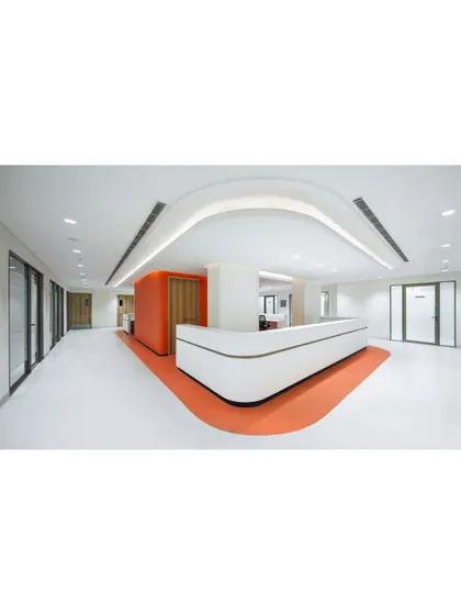 The interior of Sharda Care Healthcity features clean, modern design with intuitive wayfinding. The use of color on the floor guides visitors while the curved reception desk creates a welcoming focal point.