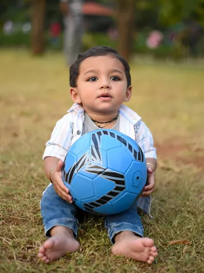 A quiet, sweet moment with the birthday boy and his soccer ball during his outdoor first birthday photoshoot.