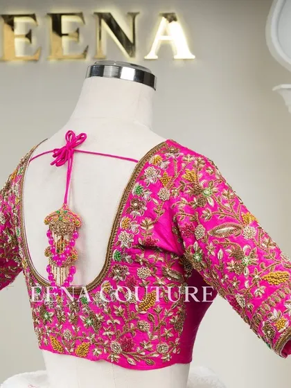 This bright pink raw silk blouse is a showcase of exquisite craftsmanship. The sleeves and back are covered in dense, multi-colored floral handwork, and I added beautiful custom tassels with bead detailing to complete the look.