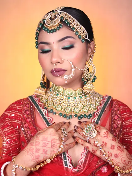 A detailed shot of the eye makeup, showing a pop of green on the lower lash line to match the jewelry, a technique we teach for cohesive looks.