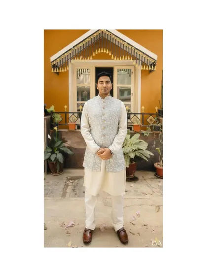 The groom, Bhuvan, stands ready for the ceremony, captured in a full-length portrait against a charming backdrop.