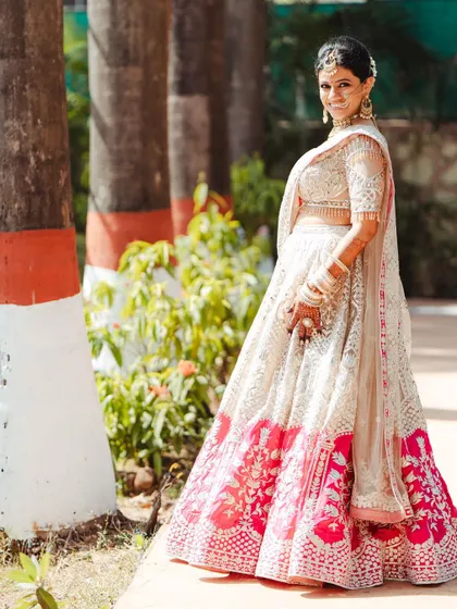 A beautiful outdoor portrait of the bride, her lehenga and smile shining in the natural light.