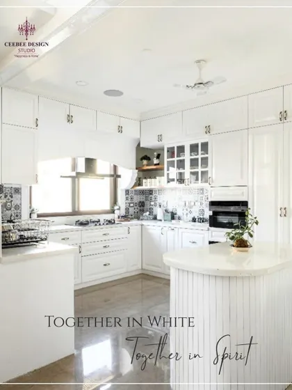 An all-white kitchen with shaker-style cabinets and patterned tile accents, creating a bright and timeless look.