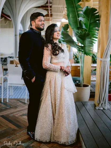 A stylish portrait of Swati and Sarthak at their engagement, showcasing their elegant outfits and the modern venue.