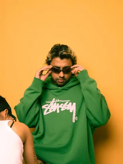 A candid moment from a photoshoot, adjusting the shades.