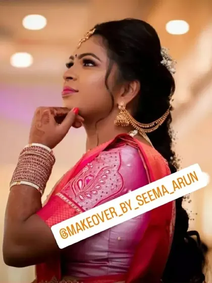 This side profile highlights the elegant hairstyle and jewellery for an engagement. The hair is styled in a modern, voluminous braid with delicate accessories, complementing the traditional jhumka earrings.