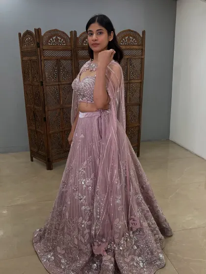 A side view showing the flow of the cape and the intricate silver floral embroidery on the lehenga.