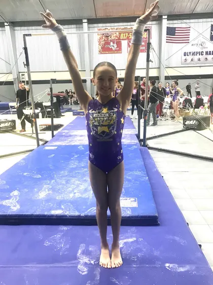 This Diamond level gymnast is all smiles and ready to take on the uneven bars at regionals.