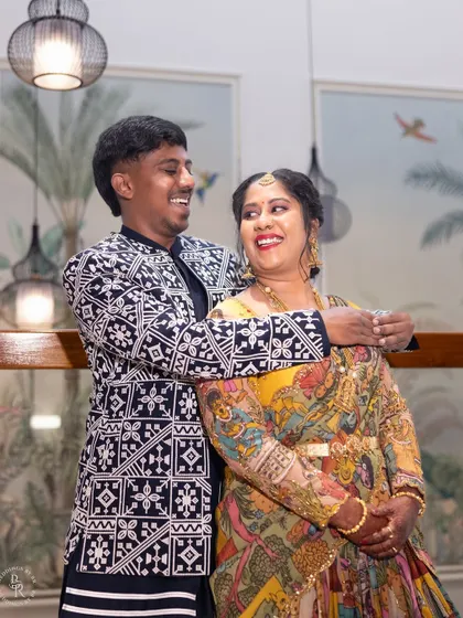 A happy, candid shot of a couple enjoying their housewarming party, their smiles reflecting the joy of the occasion.