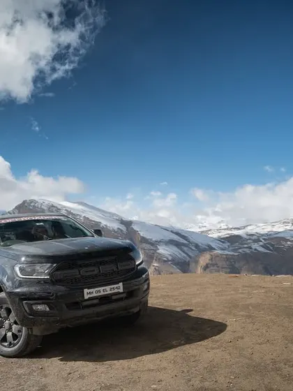 A series of images showing a convoy of 4x4 SUVs navigating the winding, mountainous roads of Spiti. These shots highlight the challenging yet rewarding nature of the expedition.