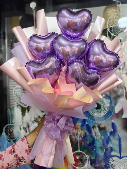 A bouquet made entirely of lilac heart shaped foil balloons. The different shades of purple and pink wrapping paper make the colors pop.