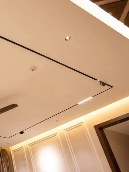 A view of a ceiling with both magnetic track lighting and cove lighting, offering maximum flexibility for any lighting mood.