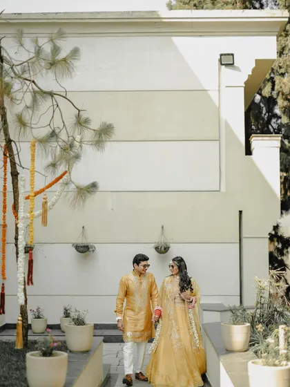 A candid-style portrait of the couple walking hand-in-hand during their daytime wedding events. The natural light and relaxed posture showcase their easy comfort and happiness with each other.