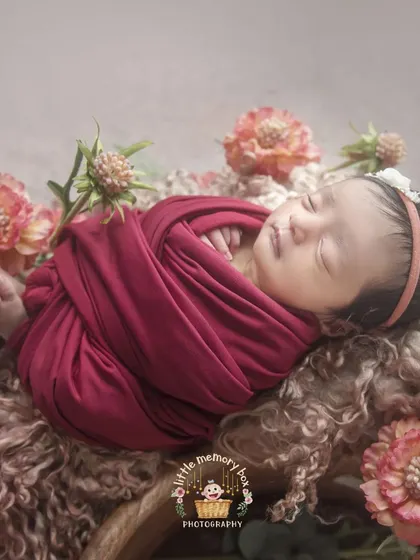 Another view of this sweet baby, showcasing the full wrap and the beautiful floral arrangement that adds a touch of nature to the portrait.