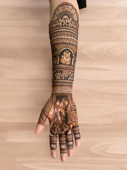 A single full-arm design showcasing a varmala scene on the palm and a Ganesha figure on the arm.