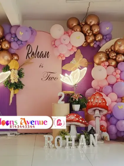 A wide view of the complete enchanted forest birthday decoration, showcasing the large marquee number '2' and the full balloon arrangement.