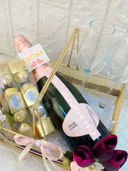 A close-up of the anniversary basket, showing the 'Perfect Together' tag, Ferrero Rocher chocolates, and a bottle of Chandon Rosé.