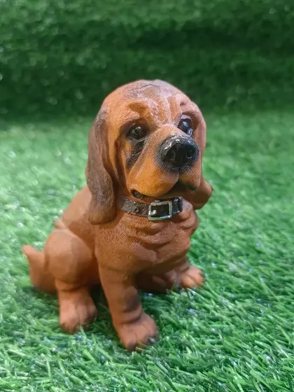 A Basset Hound puppy figurine with its characteristic droopy ears and soulful eyes.
