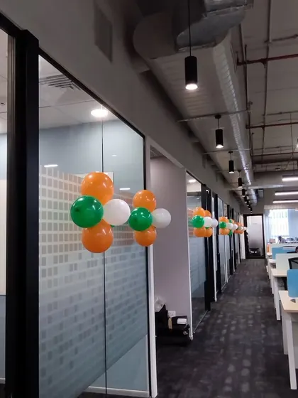 This image shows how I decorated the office hallways at DQS for Independence Day. Placing balloon clusters along the glass partitions ensures the festive theme is visible from every angle.