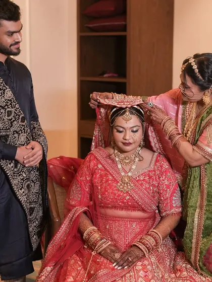 A touching family moment as the bride gets ready. Her timeless red lehenga look is completed with a soft, elegant makeup application that makes her look and feel like a queen.