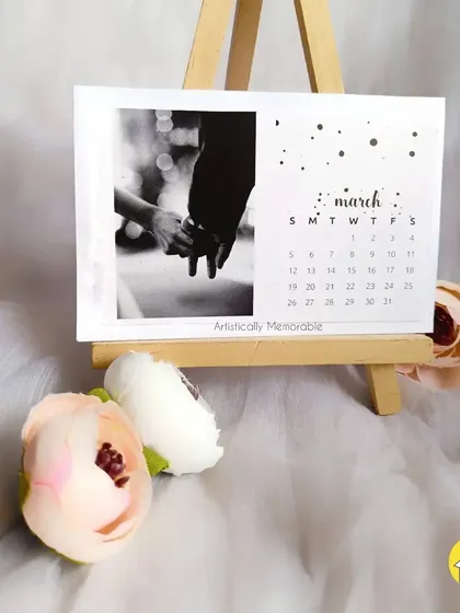 A black and white edition of the desk calendar, showing the March card with a classic photo of a couple holding hands.