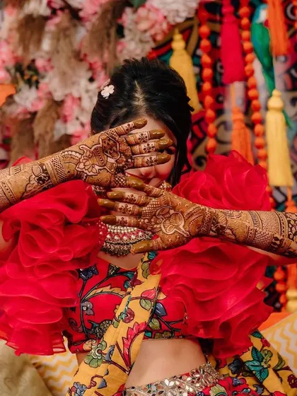 The intricate details of the bride's henna stand out against the colourful decor. I always aim to create a backdrop that complements the bride's attire and the ceremony's traditions.