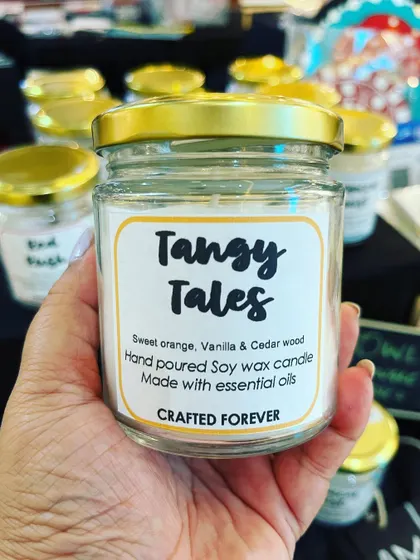 A closer look at the "Tangy Tales" candle. The scent is warm, sweet, and perfect for creating a cozy atmosphere.