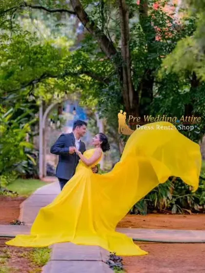 A candid moment of a couple dancing in a park. The movement of the yellow trail gown adds a sense of energy and happiness to the photo.
