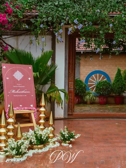 The entrance to a Muhurtham ceremony, marked by a simple yet elegant sign and traditional brass decor elements.