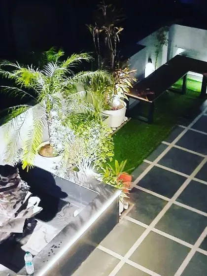 A high-angle view of the terrace landscaping, showing the water feature, planters, and seating bench, all designed to complement the glass room.