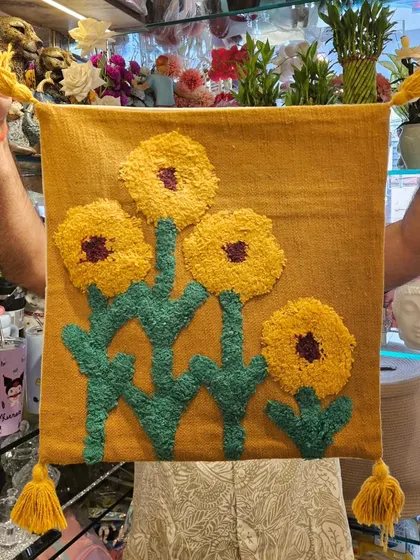 A variation of our popular sunflower tufted cushion cover, this one on a mustard yellow base. The tassels on the corners add an extra playful detail.