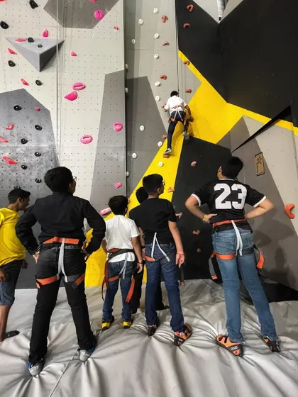A group of young climbers getting ready for their turn on the wall, all harnessed up and excited. Our classes emphasize teamwork and mutual support, creating a positive learning environment for everyone.