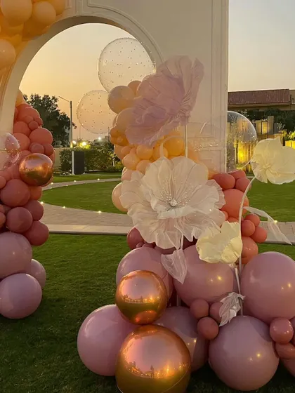 The soft light of sunset illuminates the romantic balloon arch, showcasing its beautiful color palette.