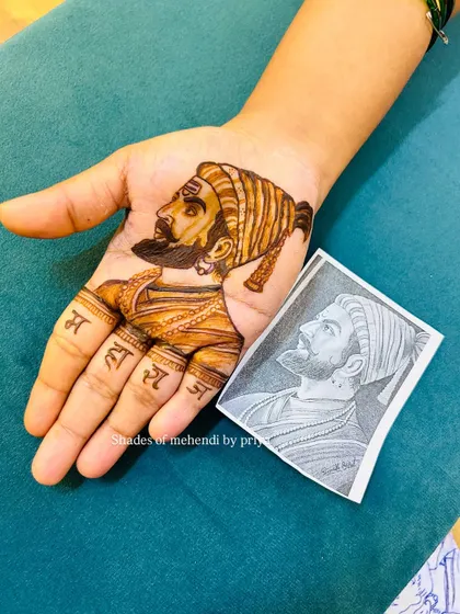 Here you can see my finished henna portrait of Shivaji Maharaj next to the reference sketch. This shows how I translate a detailed drawing into a beautiful mehendi design.
