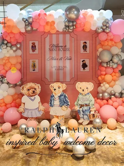 A warm baby welcome wrapped in Ralph Lauren-inspired elegance. This setup for two babies featured classic teddy bears in preppy outfits and a soft pink and peach color palette.