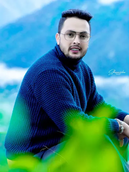 A vibrant outdoor portrait with a stunning blue mountain background. The bright colors and clear focus make this a very sharp and engaging headshot.