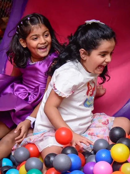 The kind of happy faces no filter can create. Two friends share a laugh as they play in the ball pit.
