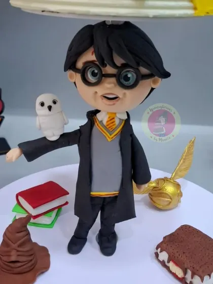 A detailed close-up of the handcrafted Harry Potter figurine, complete with his owl Hedwig and the golden snitch.