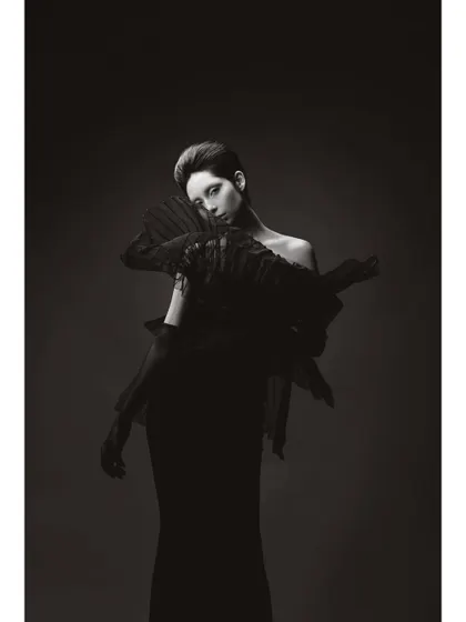 A black and white portrait of 'Athena'. This minimalist composition focuses on the sharp, angular lines of the styling and the model's striking features, creating a timeless and graphic image.