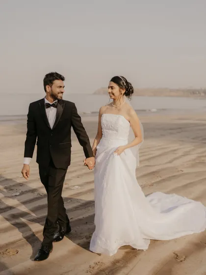 The couple walking hand-in-hand on the beach, a classic and timeless romantic shot.
