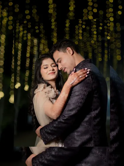 An intimate embrace between the newly engaged couple, set against a beautiful bokeh background of festive lights.
