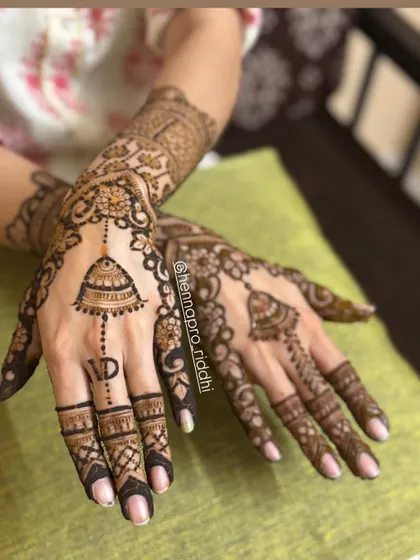 A simple yet elegant back-hand design. The hanging jhumka motif is a popular choice, and I've paired it here with detailed finger work and the initial 'V' for a personal touch.