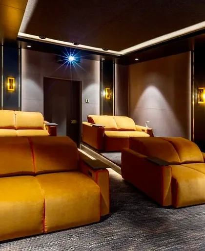 The tiered seating in this theater ensures that even with multiple rows of sofas, everyone gets a clear and comfortable view.