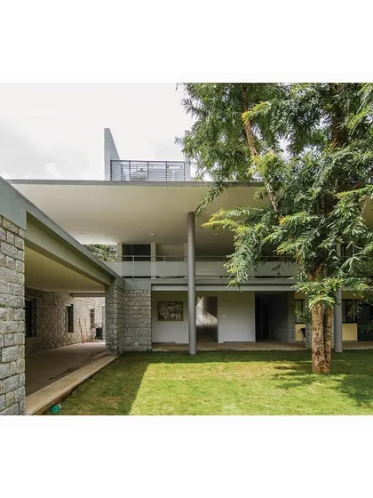 The new block is carefully sited to preserve existing trees, which become integral elements of the architecture.