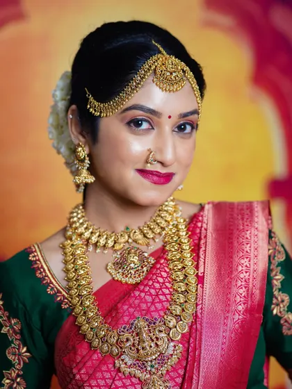 A beautiful portrait of a bride, showcasing the intricate details of the temple choker, haara, and matha patti.