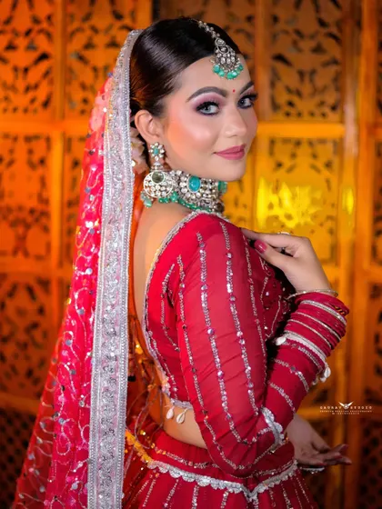 An over-the-shoulder look from the bride, giving a glimpse of her back and the sheer, elegant dupatta. Her smile makes the shot warm and inviting.