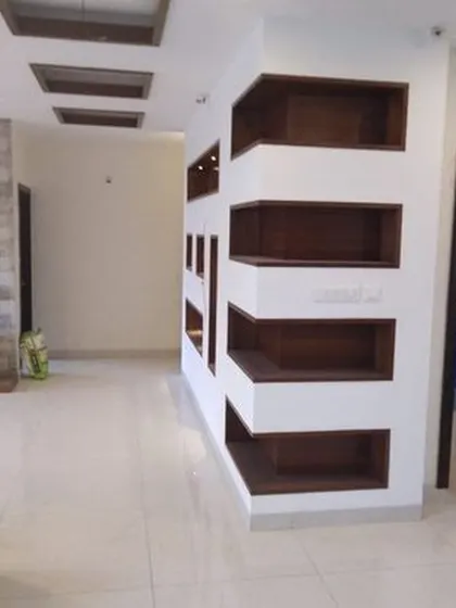 A functional and stylish partition wall with built-in display niches in a contrasting wood finish. This design serves as both a room divider and a decorative shelving unit.
