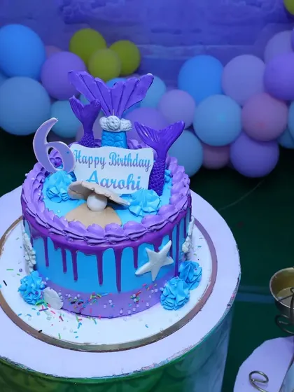 A close-up of a custom mermaid-themed birthday cake. We can coordinate with your baker or suggest one to ensure every element of the party, including the cake, matches the theme perfectly.