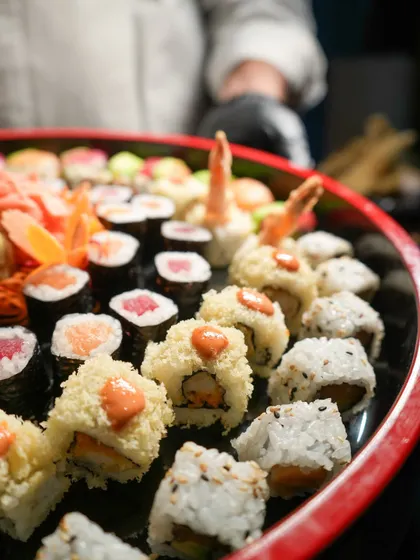A glimpse of one of our large party platters being prepared by our chef. This spread includes a mix of tempura prawn rolls, classic tuna maki, and other house favorites, ready for a celebration.